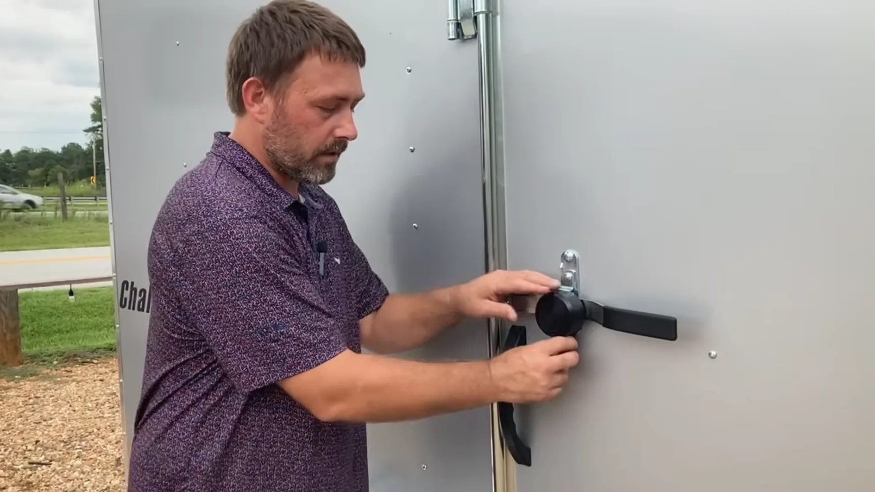 Screenshot 2026-09-08 at 2.45.33 PM Man installing puck lock on enclosed trailer